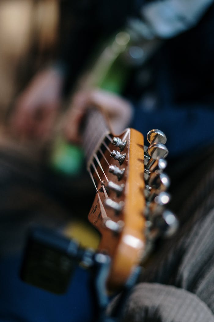 services-03 Artistic shot of an electric guitar headstock with blurred background, perfect for music themes.